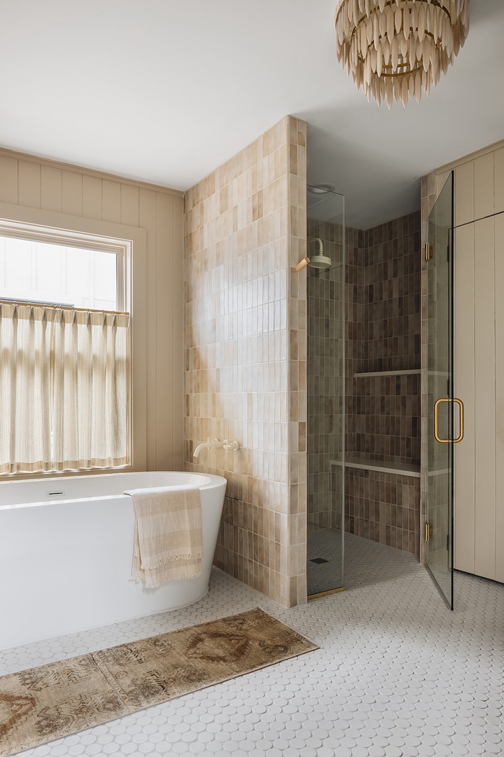 Besides a sleek relaxing tub, this bathroom features a tiled walk-in shower.