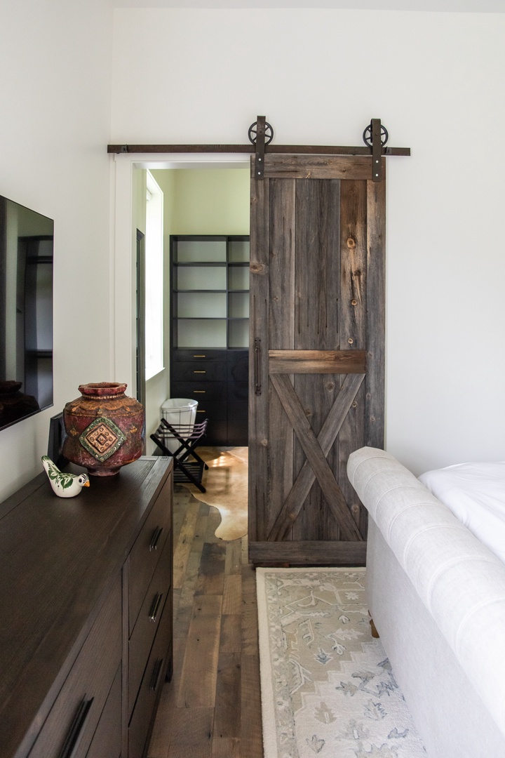 A classic barn door leads to the main bedroom’s closet.