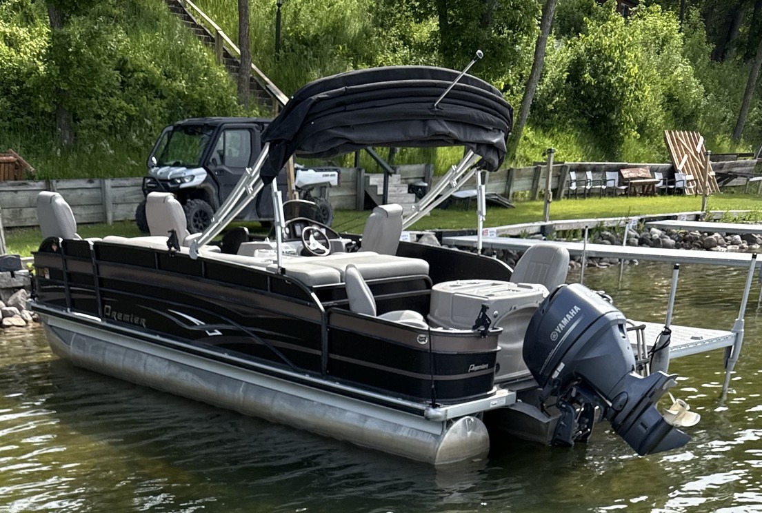A sleek pontoon boat awaits at the private dock, surrounded by lush greenery and calm waters—your gateway to relaxing lake adventures.