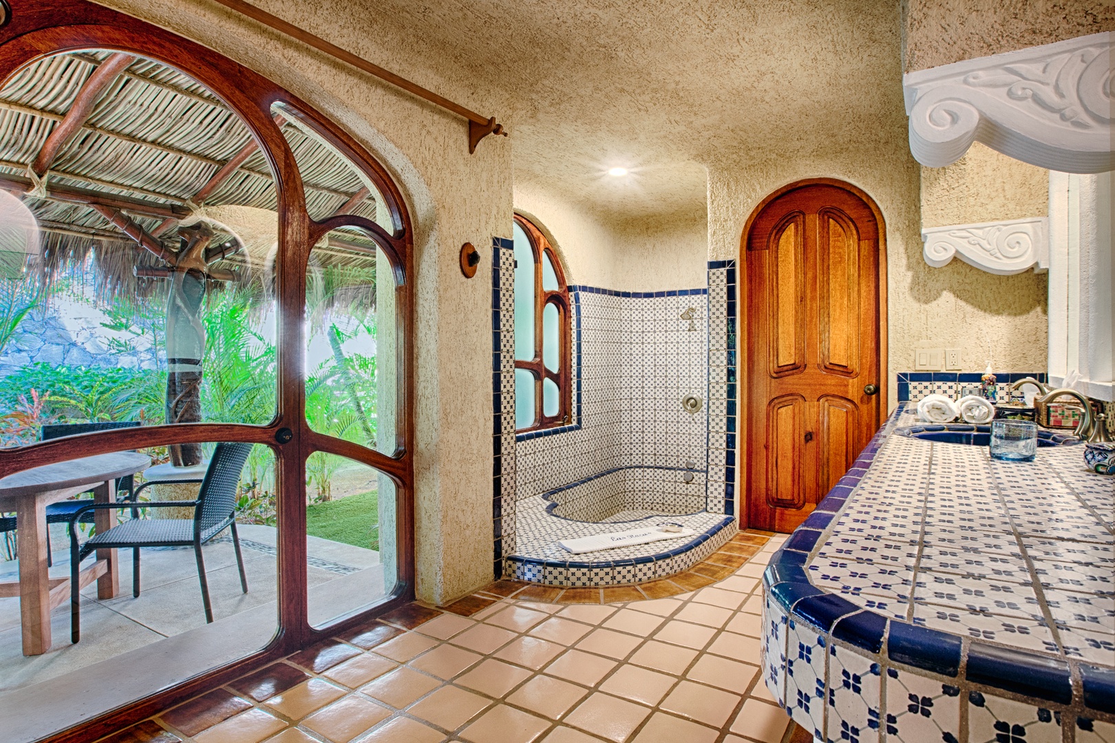 Your luxurious master suite features an ornate tiled jacuzzi, beautiful arched windows, and authentic architectural details for ultimate relaxation.