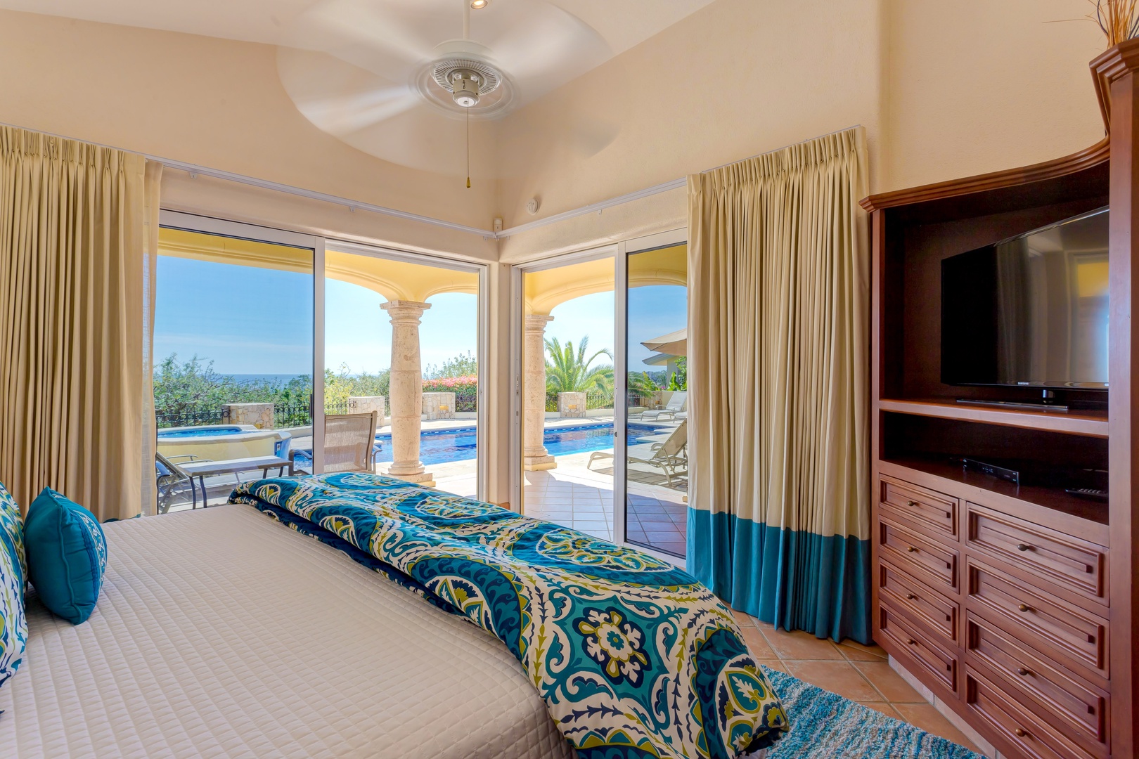 Wake up to stunning pool views from your comfortable bedroom, where floor-to-ceiling windows frame the sparkling water and tropical paradise beyond.