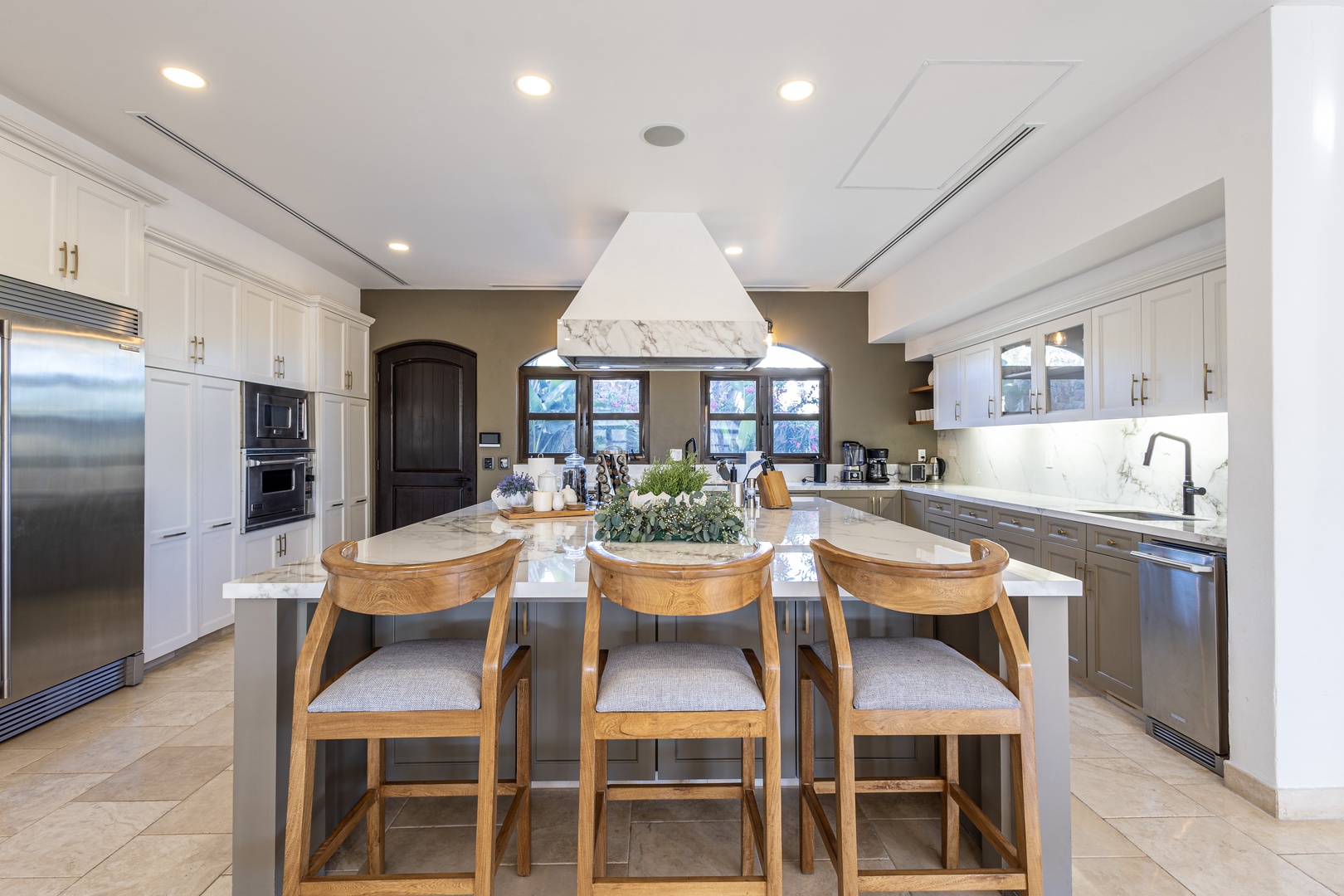 This stunning chef's kitchen features elegant marble countertops, premium stainless appliances, and a spacious island where you can gather with loved ones for meals and memories.