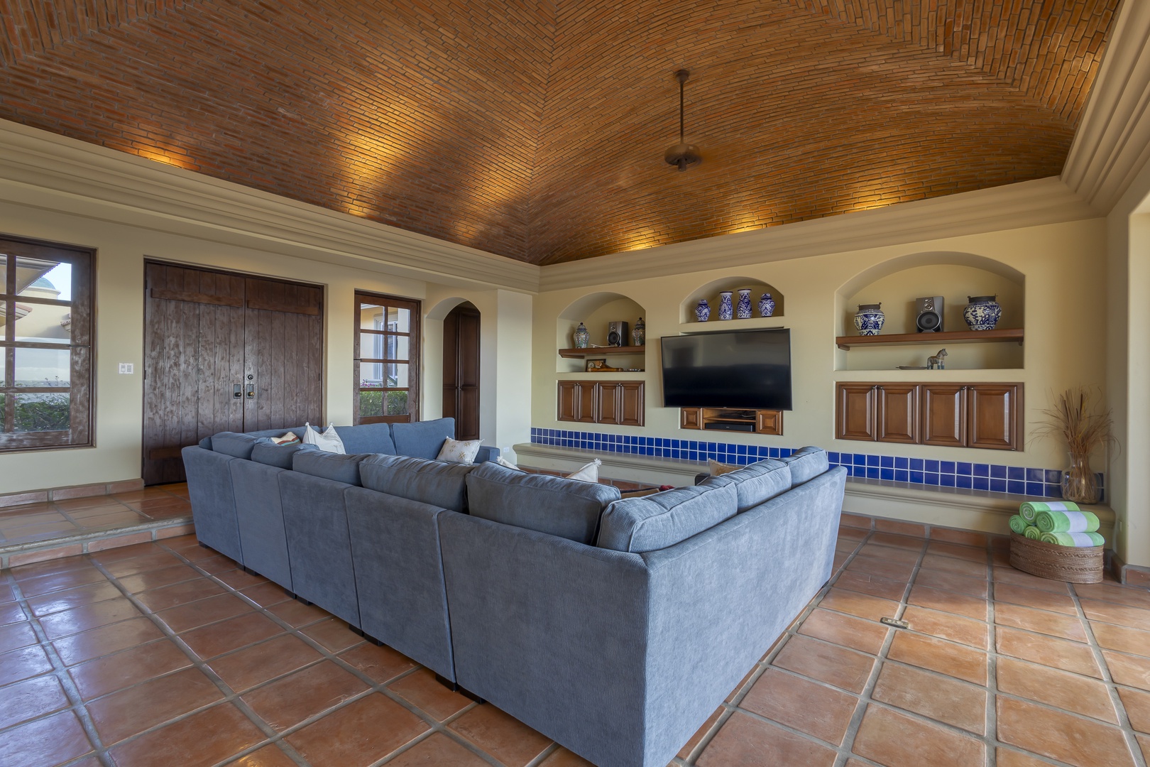 Relax in your spacious living room with soaring brick ceilings, plush sectional seating, and entertainment center for cozy evenings together.