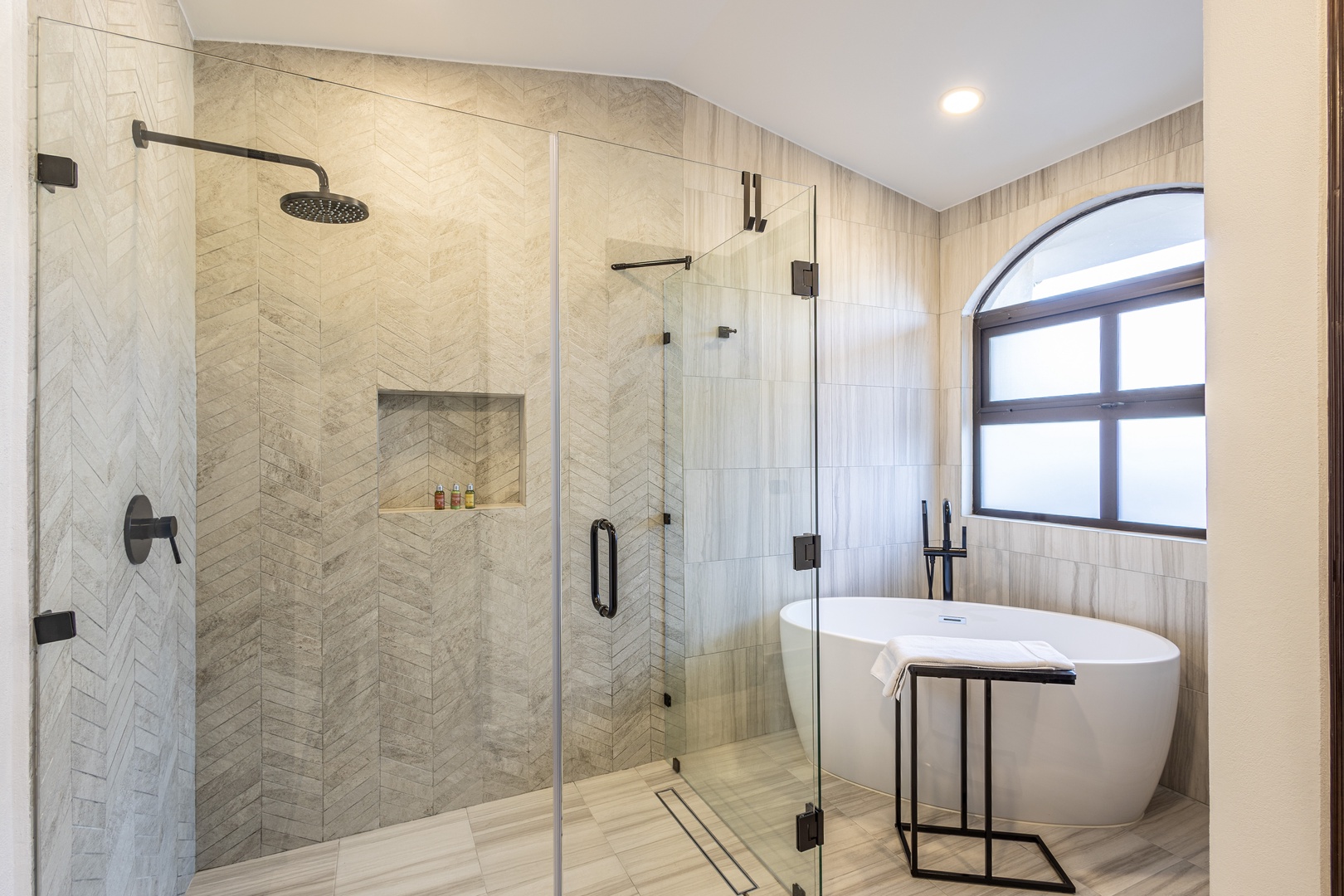 Unwind in your private spa-like bathroom, featuring a luxurious soaking tub and spacious walk-in shower with elegant herringbone tile—your personal retreat after each day's adventures.