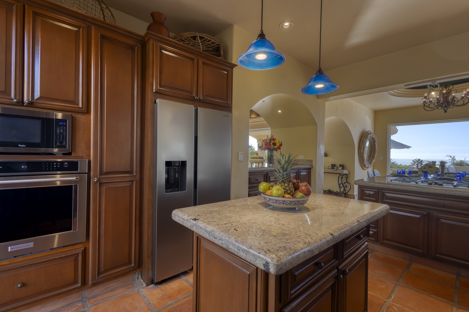 Your gourmet kitchen awaits with granite counters, blue pendant lights, and premium appliances—perfect for creating memorable meals together.
