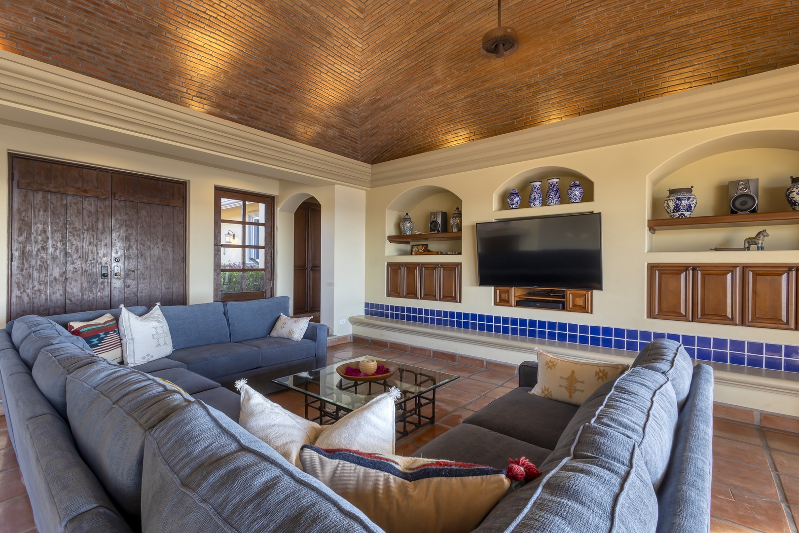 Sink into plush sectional seating beneath stunning brick vaulted ceilings, where your evenings unfold with entertainment and handcrafted Mexican tile details.