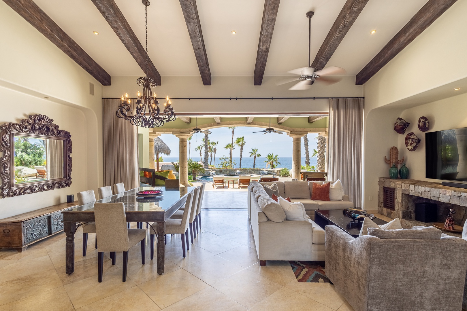 Relax in your stunning great room where rustic beams meet ocean views. You'll love the seamless indoor-outdoor flow to your private terrace.