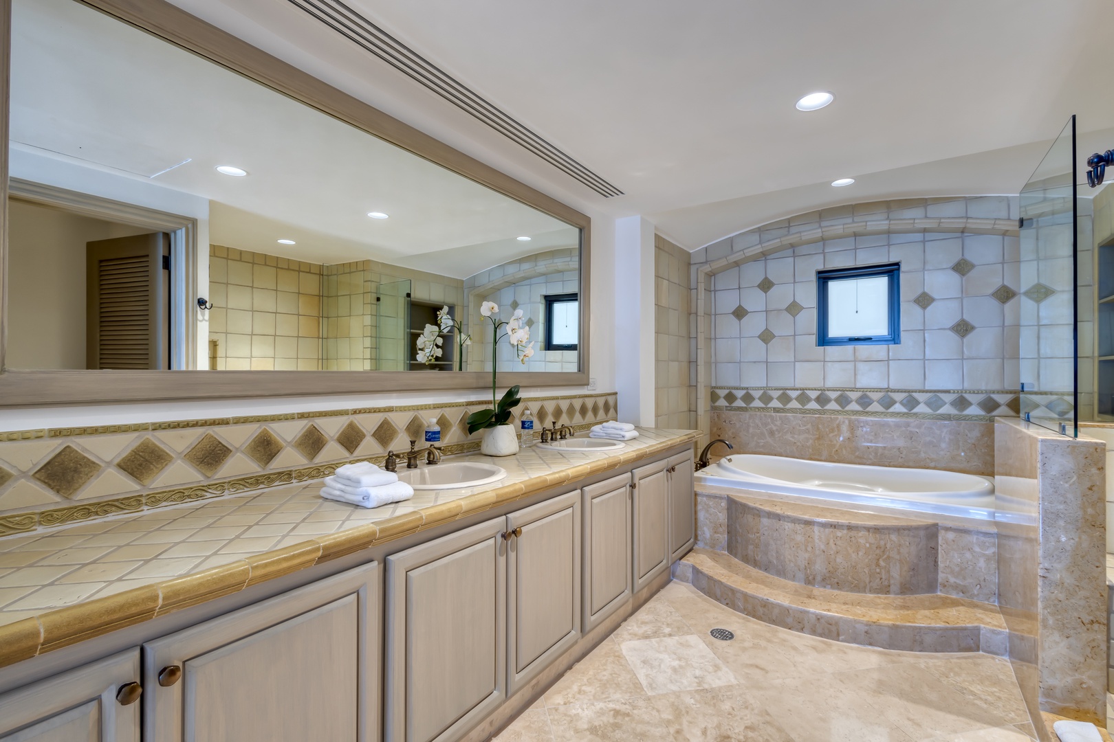Your private spa-like bathroom features a luxurious soaking tub, elegant tiled finishes, and a spacious vanity where you can unwind in complete comfort after a day of adventure.