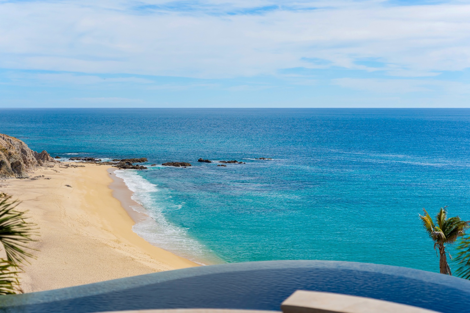 Stunning oceanfront location with pristine beach and crystal-clear turquoise waters stretching to the horizon.