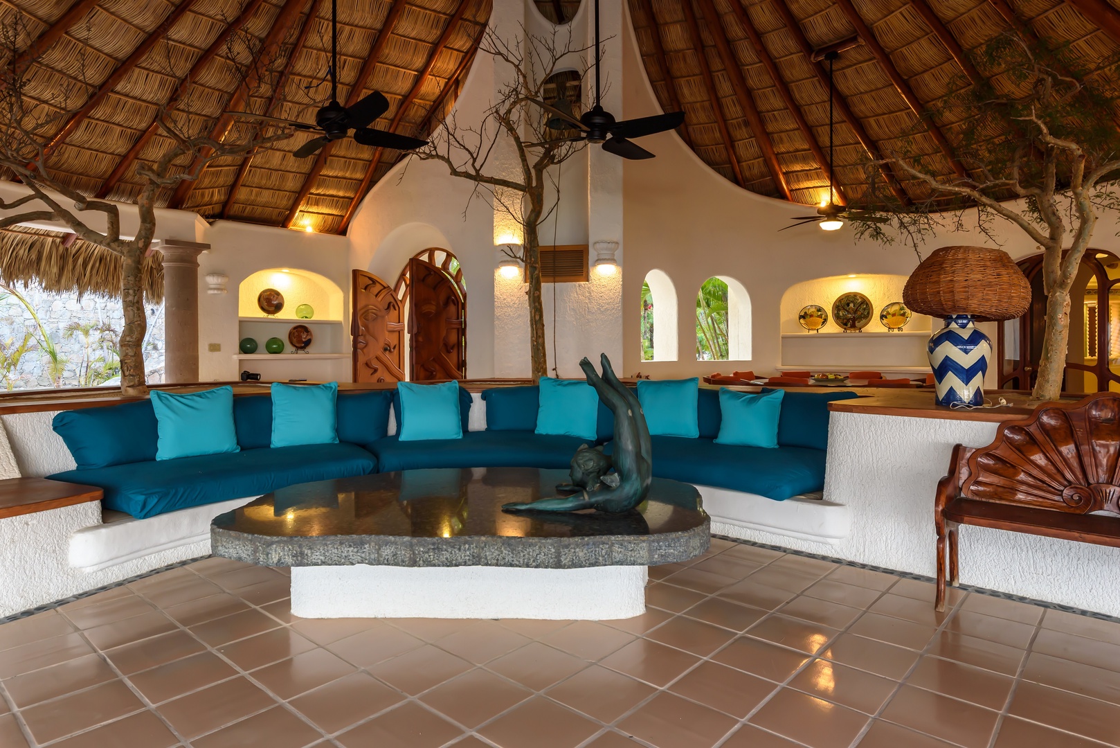 Step into your private oasis with soaring palapa ceilings, vibrant turquoise seating, and artistic details that blend tropical elegance with authentic Mexican charm—your perfect retreat awaits.