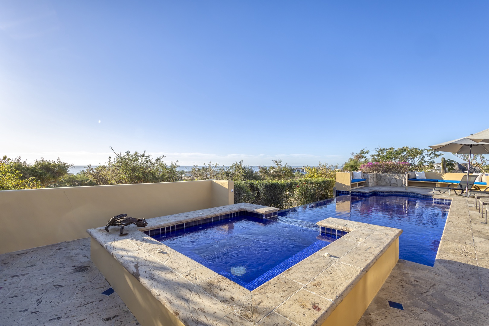 Sparkling pool and hot tub await with panoramic mountain views under endless blue skies—your perfect escape.