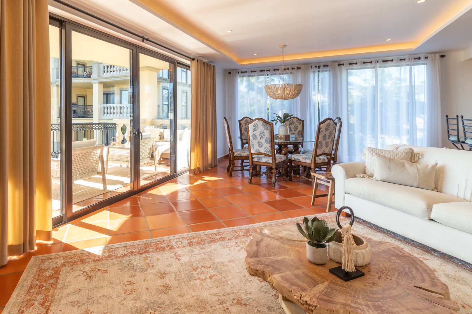 Relax in your sun-drenched living and dining space, where elegant furnishings meet terracotta warmth. Step through glass doors to your private balcony and let the light wrap around you.