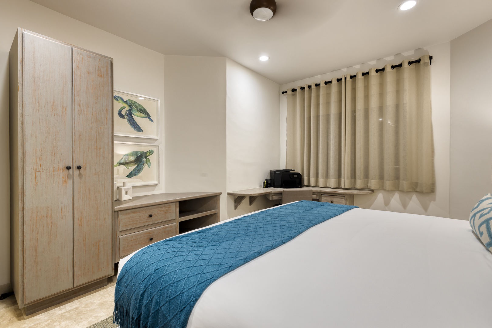 Unwind in your coastal-inspired bedroom featuring crisp linens, a plush bed, and serene turtle artwork—your perfect retreat for restful nights.
