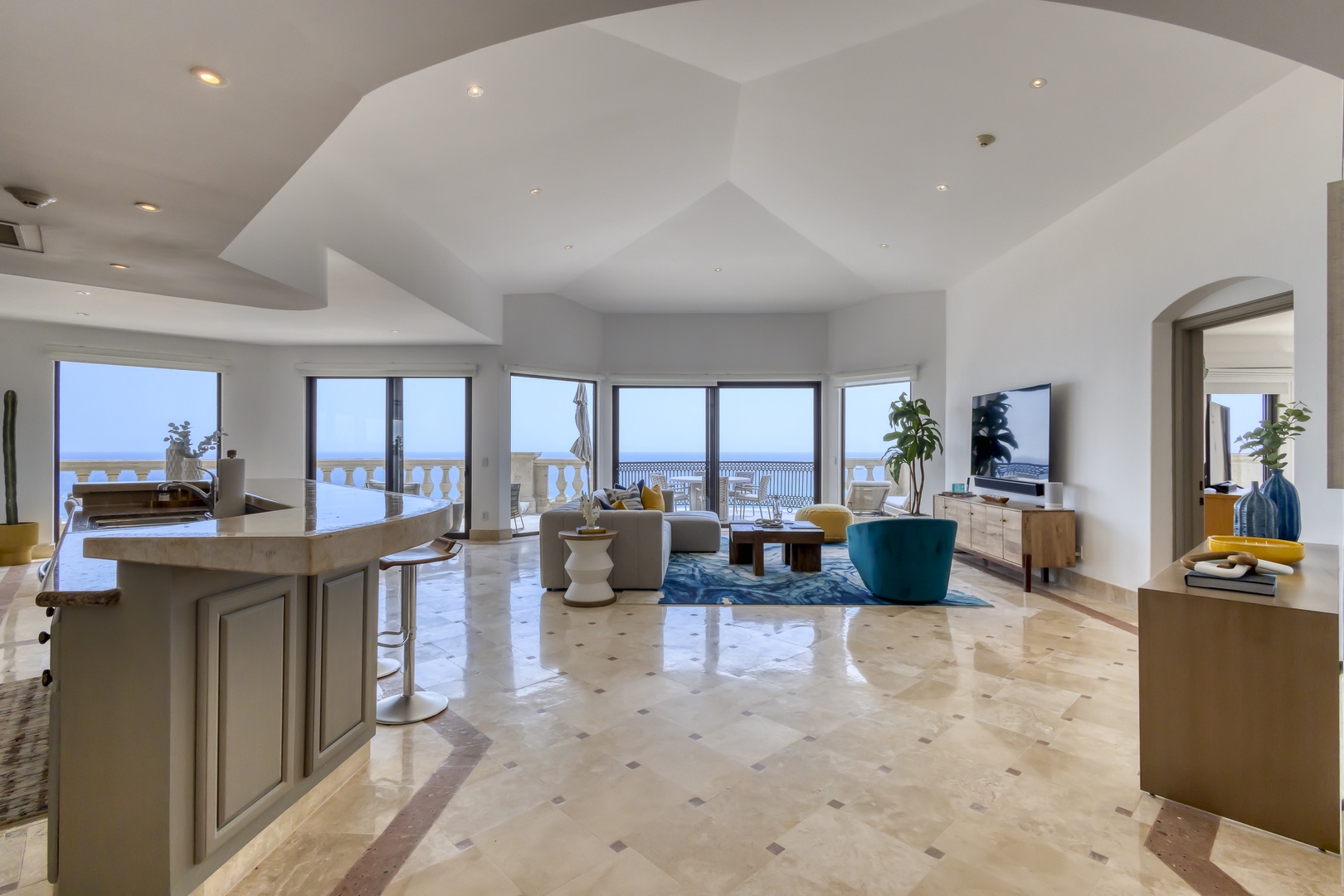 Step into a stunning open-concept living space where sweeping sea views meet elegant interiors. Sunlight pours through expansive windows as you relax in the inviting lounge or dine with the ocean as your backdrop.