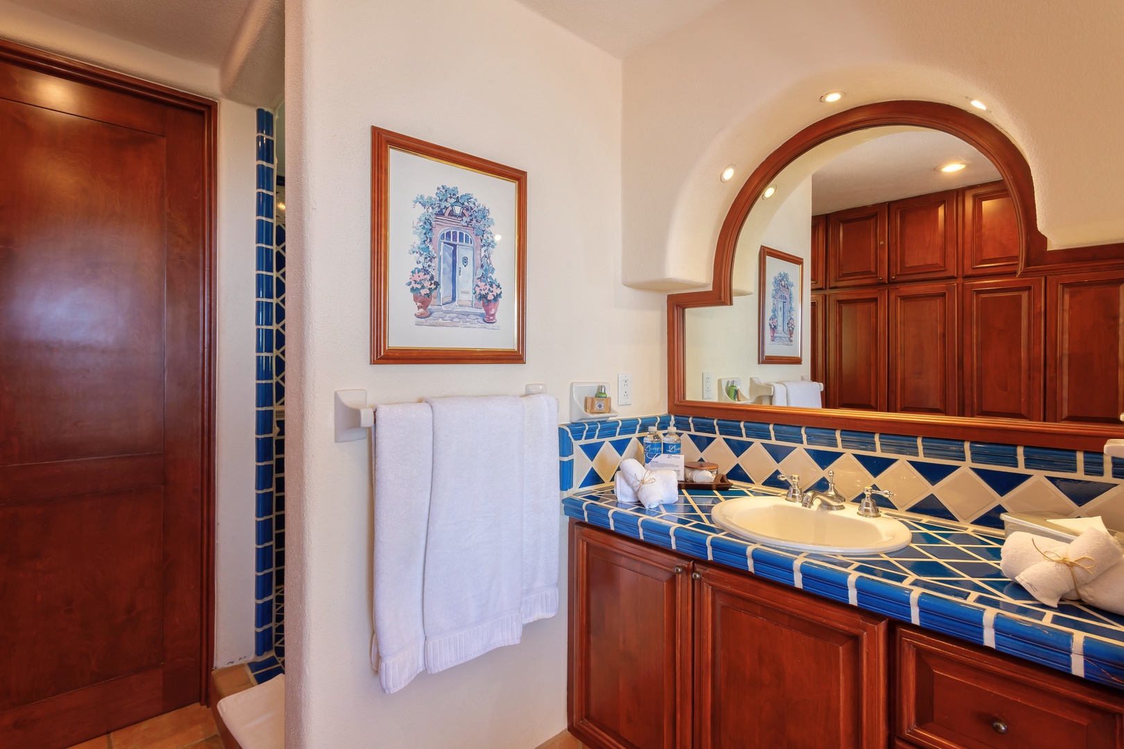 Beautiful handcrafted blue tilework and rich wood vanity create your elegant bathroom sanctuary.
