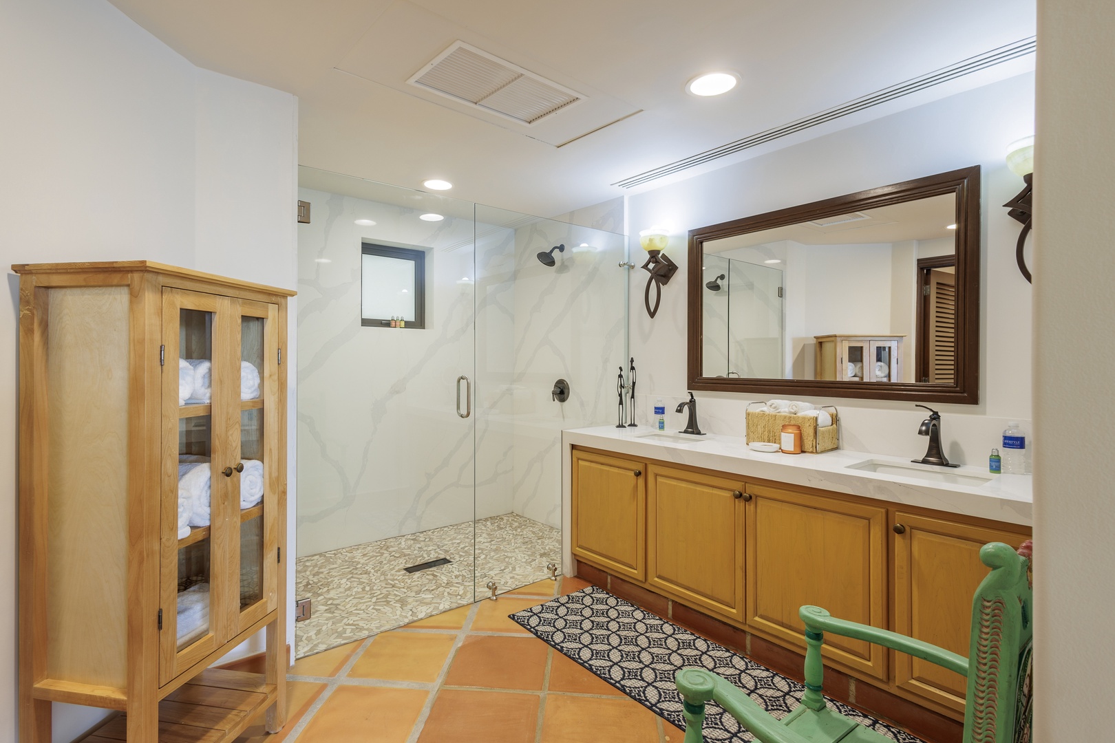 Your spacious ensuite features a beautiful walk-in shower, dual vanities, and warm wood cabinetry. Fresh linens await in the elegant towel cabinet.