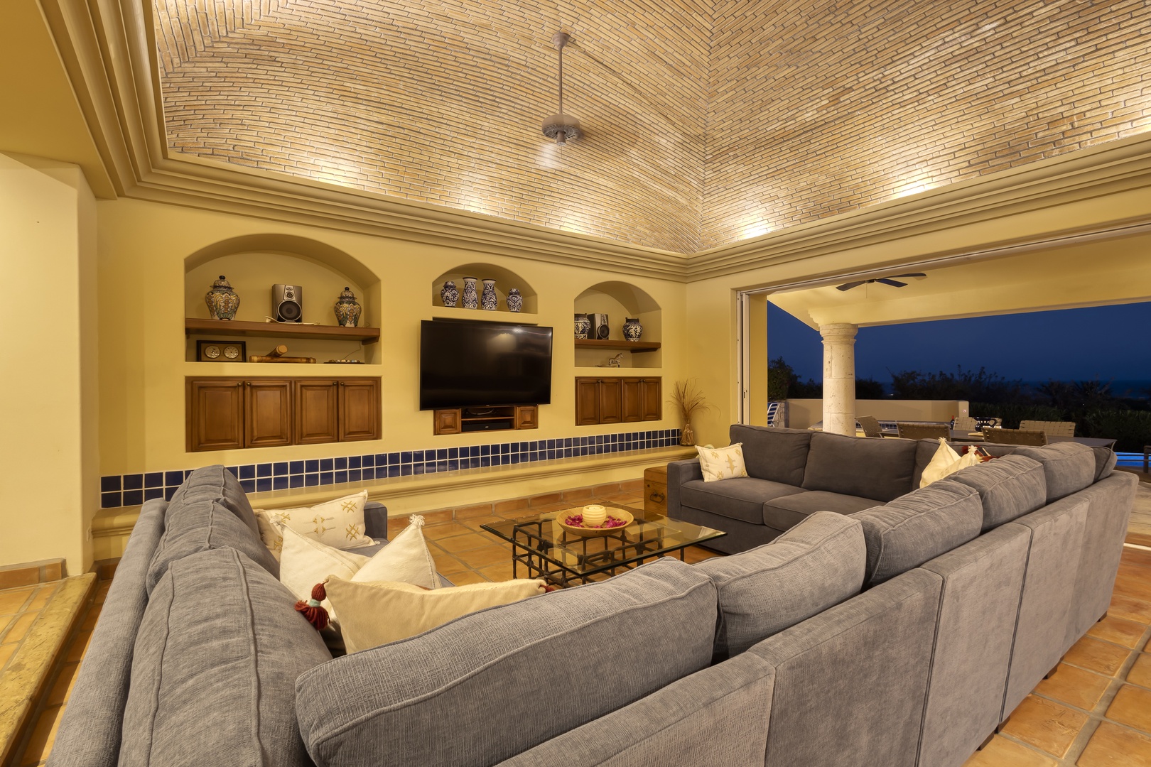 Gather your group in this spacious living room featuring plush sectional seating and stunning brick-vaulted ceilings that create an elegant atmosphere.