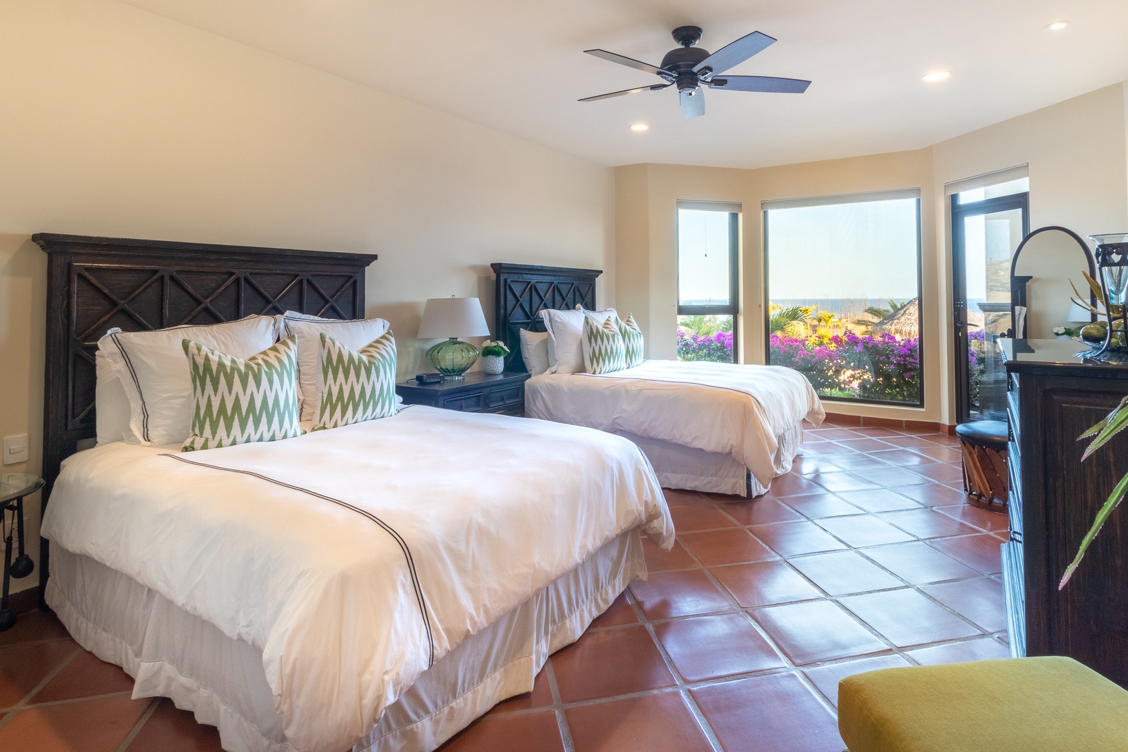 Wake up to vibrant garden views and ocean glimpses from your sun-filled bedroom. Two plush beds, cool tile floors, and a ceiling fan ensure your comfort year-round.