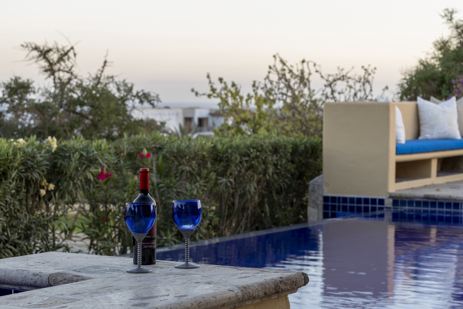 Unwind poolside with wine and peaceful garden views creating your perfect evening retreat.