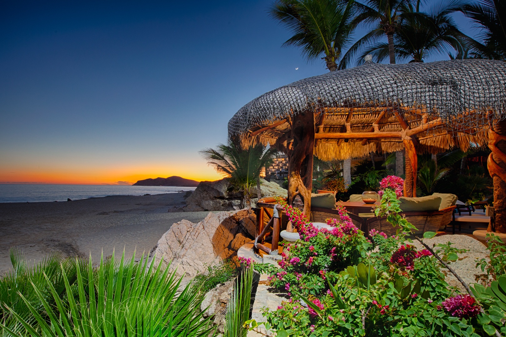 Beachfront paradise featuring tropical gardens and sunset views over the ocean with comfortable seating areas.