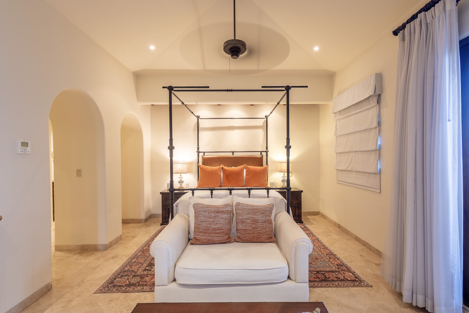 Step into your serene bedroom featuring a statement four-poster bed, elegant archways, and a cozy seating area—your personal sanctuary designed for ultimate relaxation and comfort.