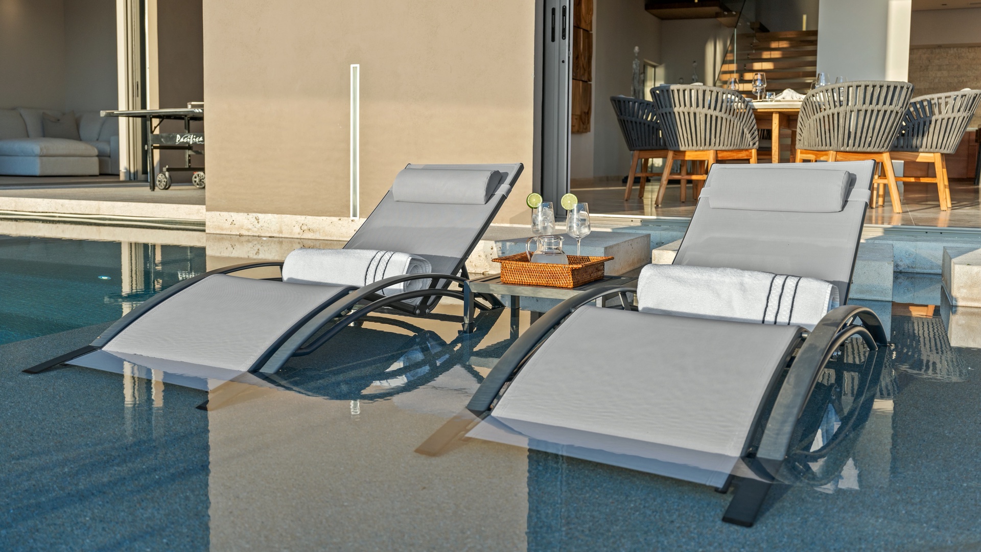 Unwind in your private poolside retreat with luxurious loungers and refreshing drinks waiting. This sun-drenched terrace connects seamlessly to your modern dining and living spaces for effortless indoor-outdoor living.