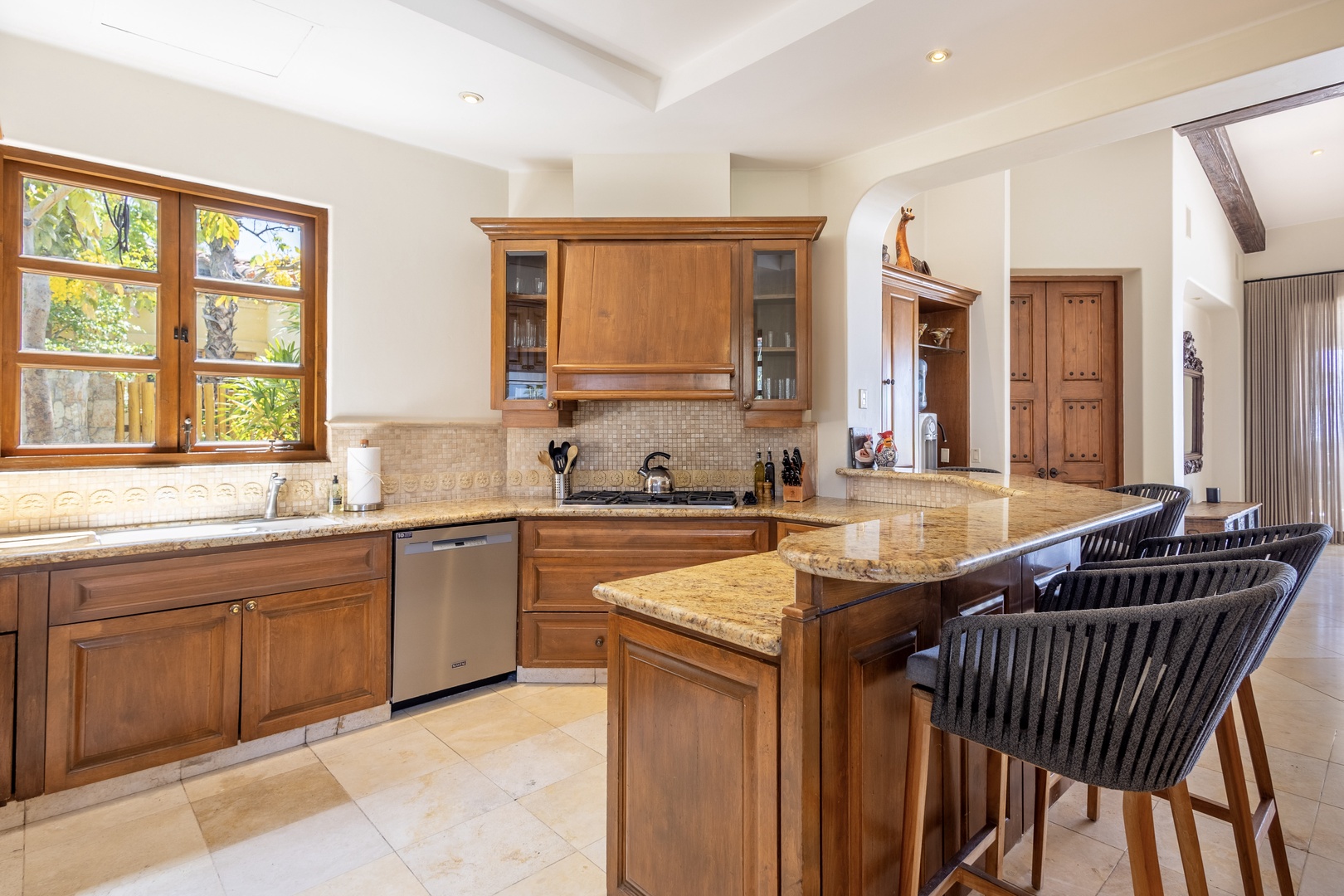 Your gourmet kitchen awaits with rich wood cabinets, granite counters, and breakfast bar perfect for morning coffee or cooking together.