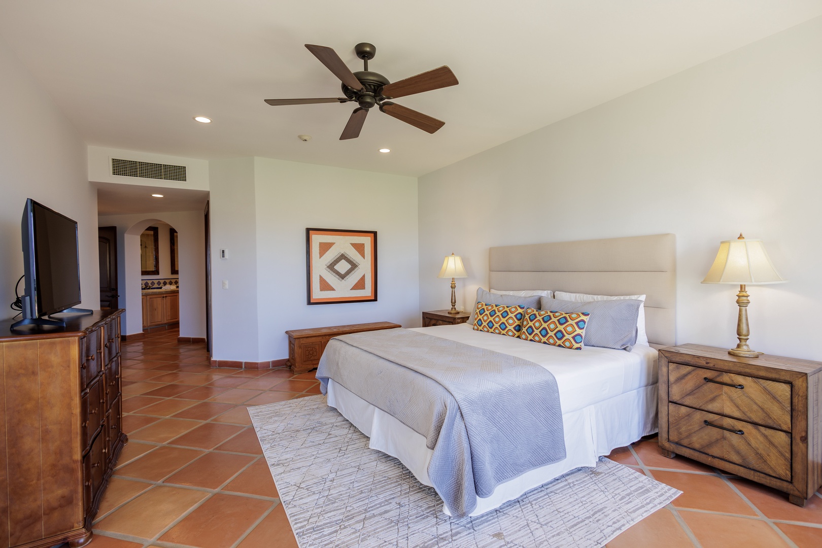 Your spacious primary suite invites comfort with a plush king bed, ceiling fan, and private en-suite, offering the perfect retreat after days of adventure and exploration.