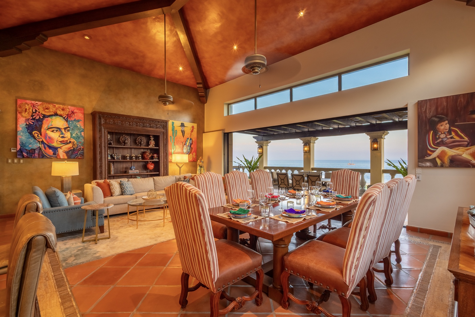 Gather around the dining table with ocean views framing your meals, or sink into the cozy living area where warm wood tones and vibrant art create an inviting ambiance for your stay.