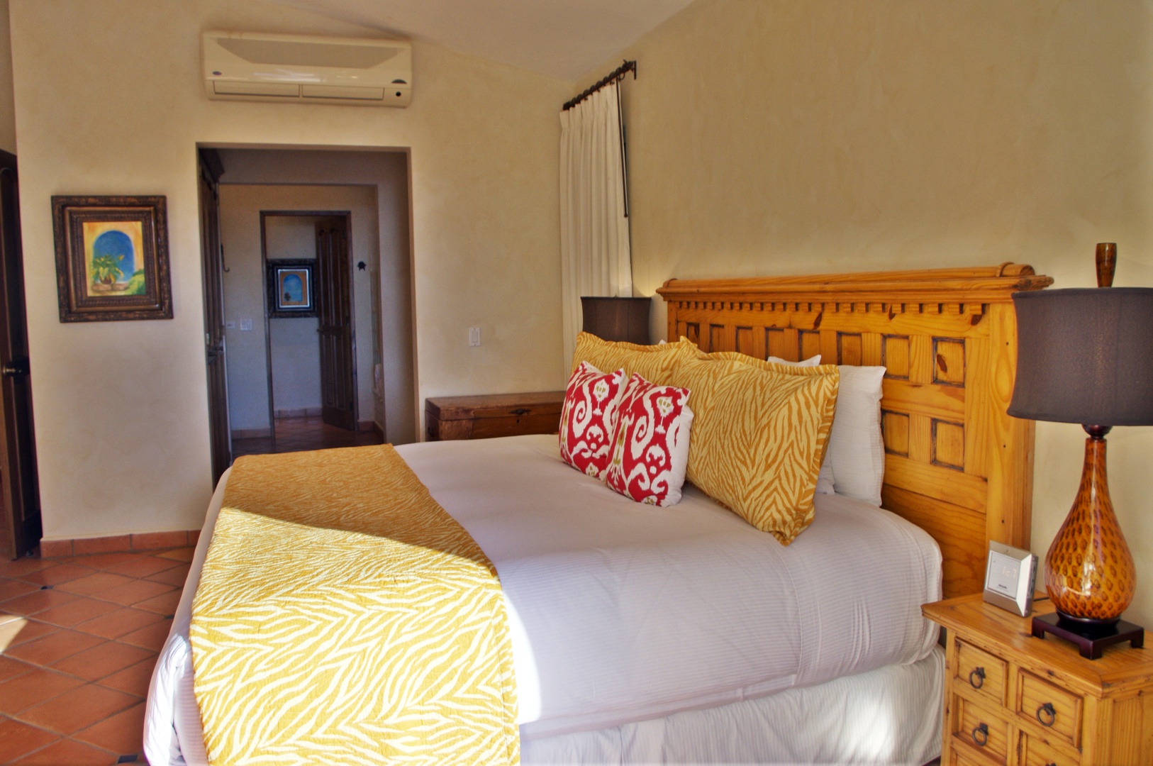 Sink into your plush bed with vibrant accent pillows after a refreshing day exploring. Cool comfort awaits with climate control overhead and charming decor welcoming you home.