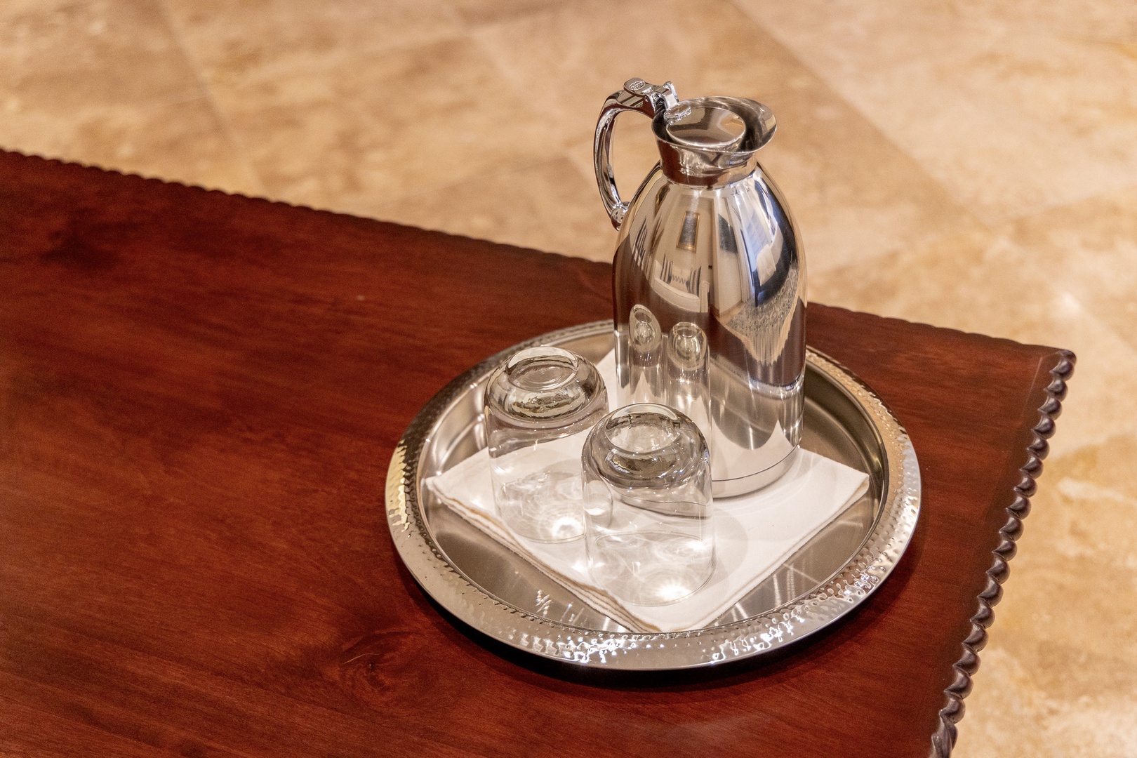 A polished silver carafe and glasses await your arrival, ready to refresh you after a day of exploring.
