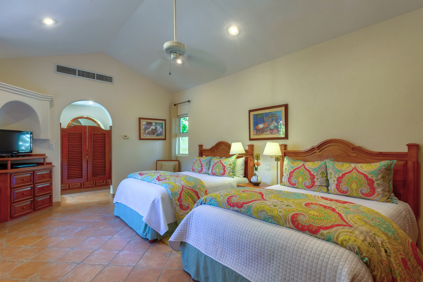 Unwind in your spacious twin bedroom with vibrant tropical bedding, warm wood furnishings, and thoughtful touches that create a perfect island retreat.