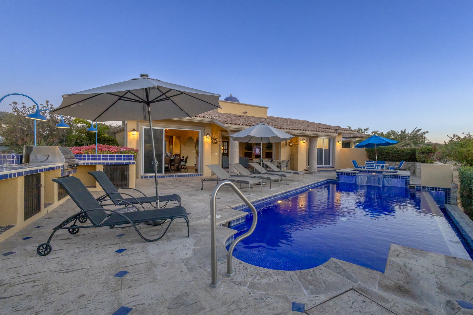 Luxurious villa with sparkling blue pool, elegant outdoor seating, and stunning desert landscape surroundings for the perfect getaway.