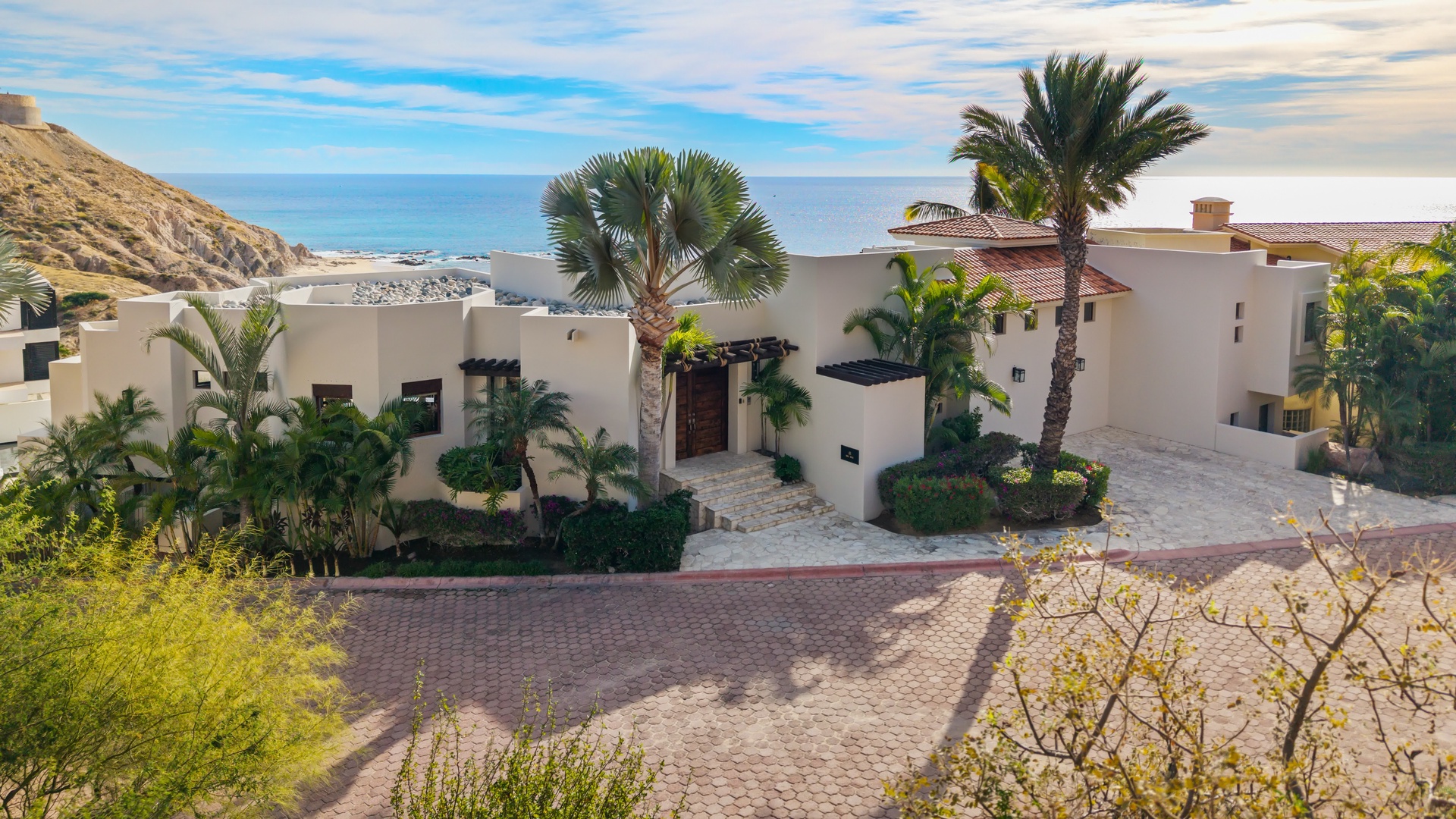 Luxurious beachfront villa with tropical landscaping and stunning ocean views in an exclusive coastal setting.
