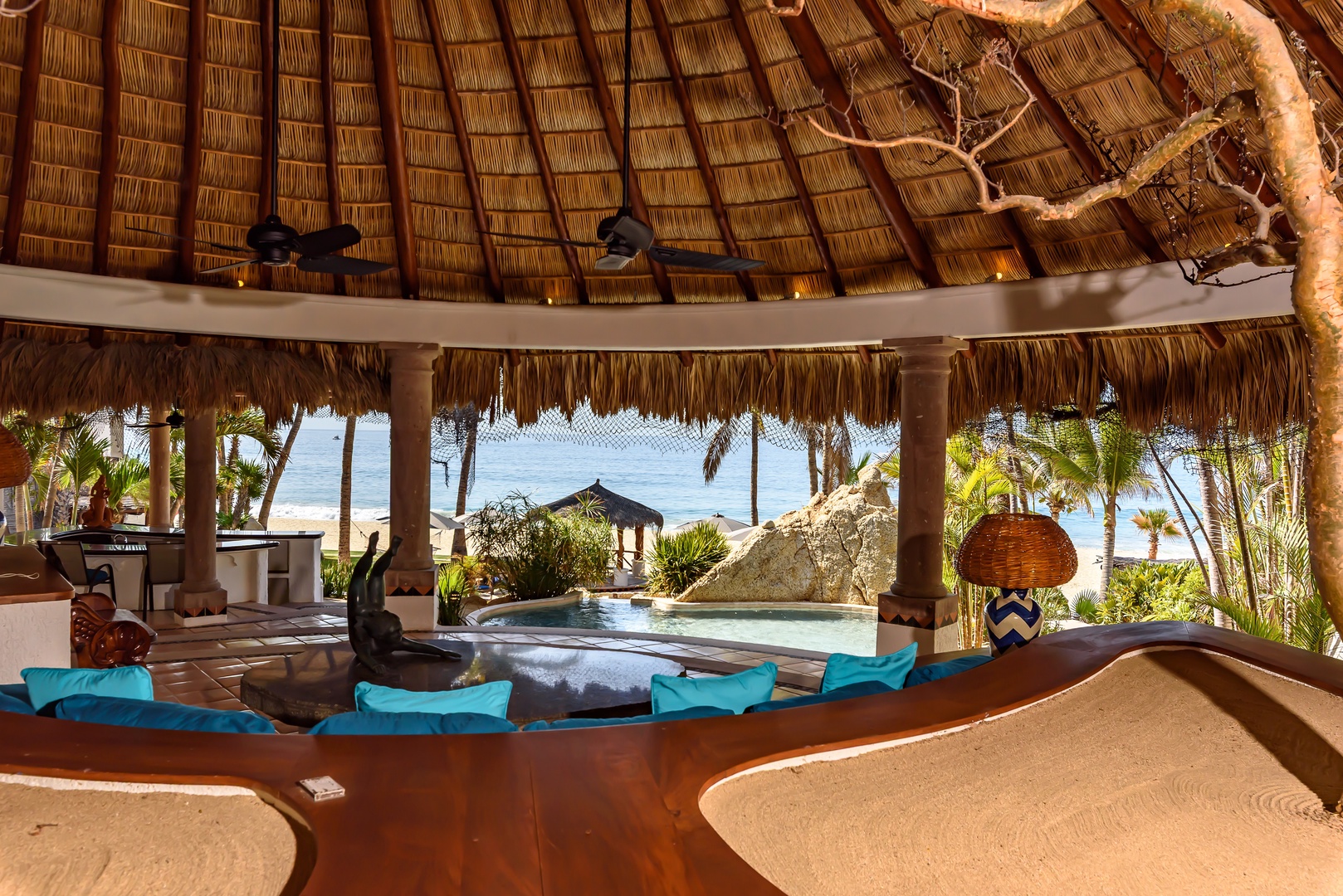 Sink into plush seating under a thatched palapa as you take in stunning ocean views, swaying palms, and the soothing sounds of the waves just beyond your private pool.
