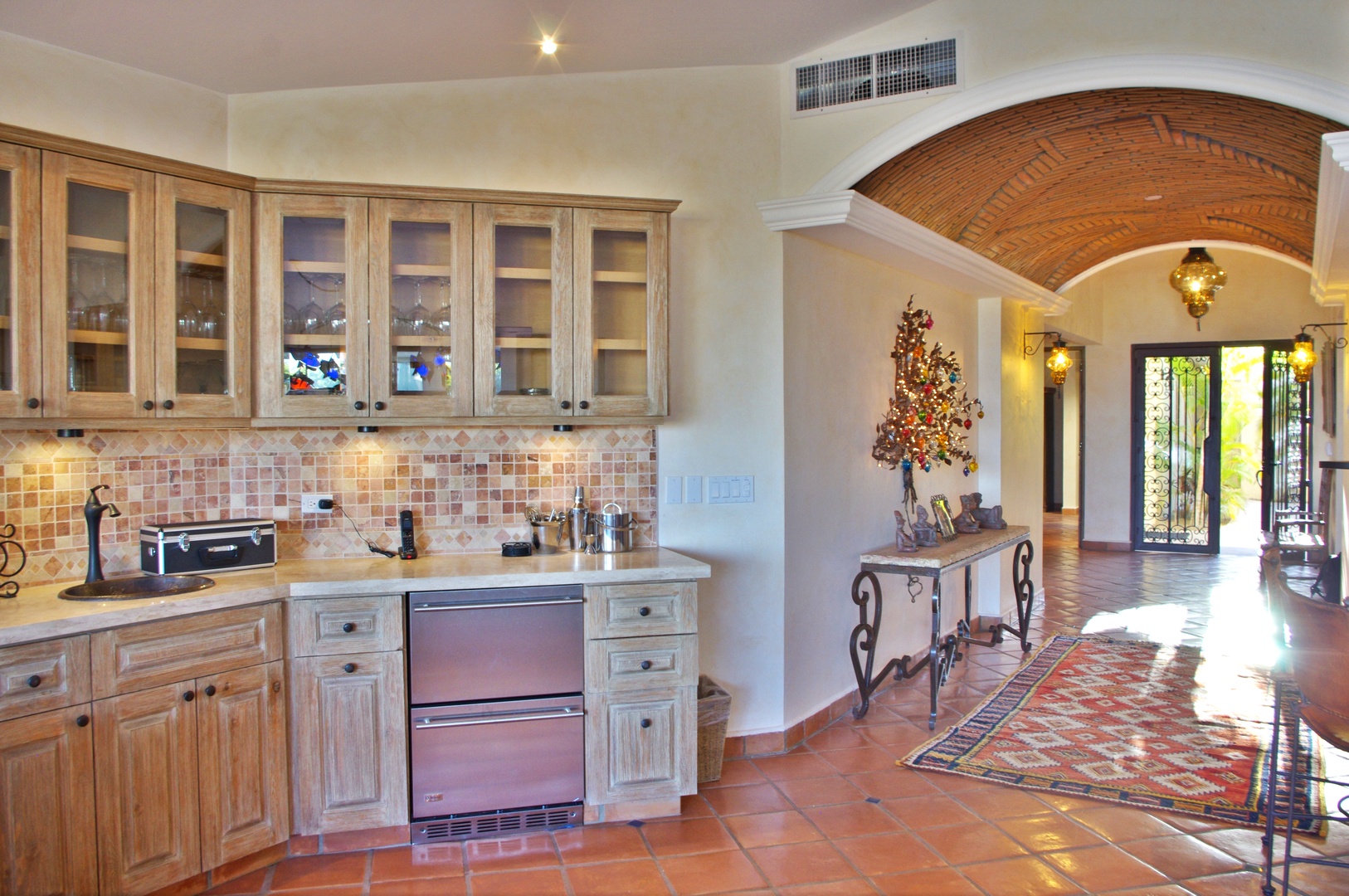 Step into your private retreat where warm terracotta tiles lead through elegant archways to sun-drenched comfort. Your fully equipped kitchenette features handcrafted cabinetry and mosaic backsplash for easy meal prep.