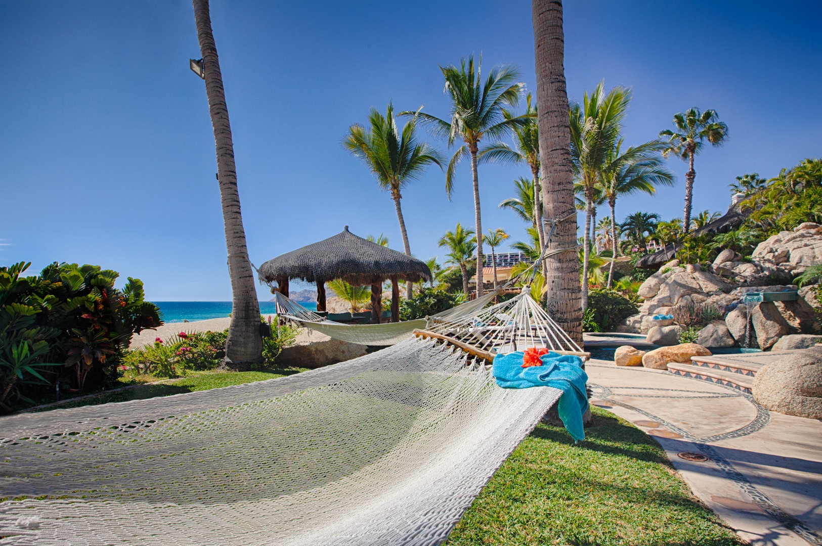 Sway gently in your private hammock while ocean breezes whisper through palm trees and crystal-clear waters beckon just steps away.