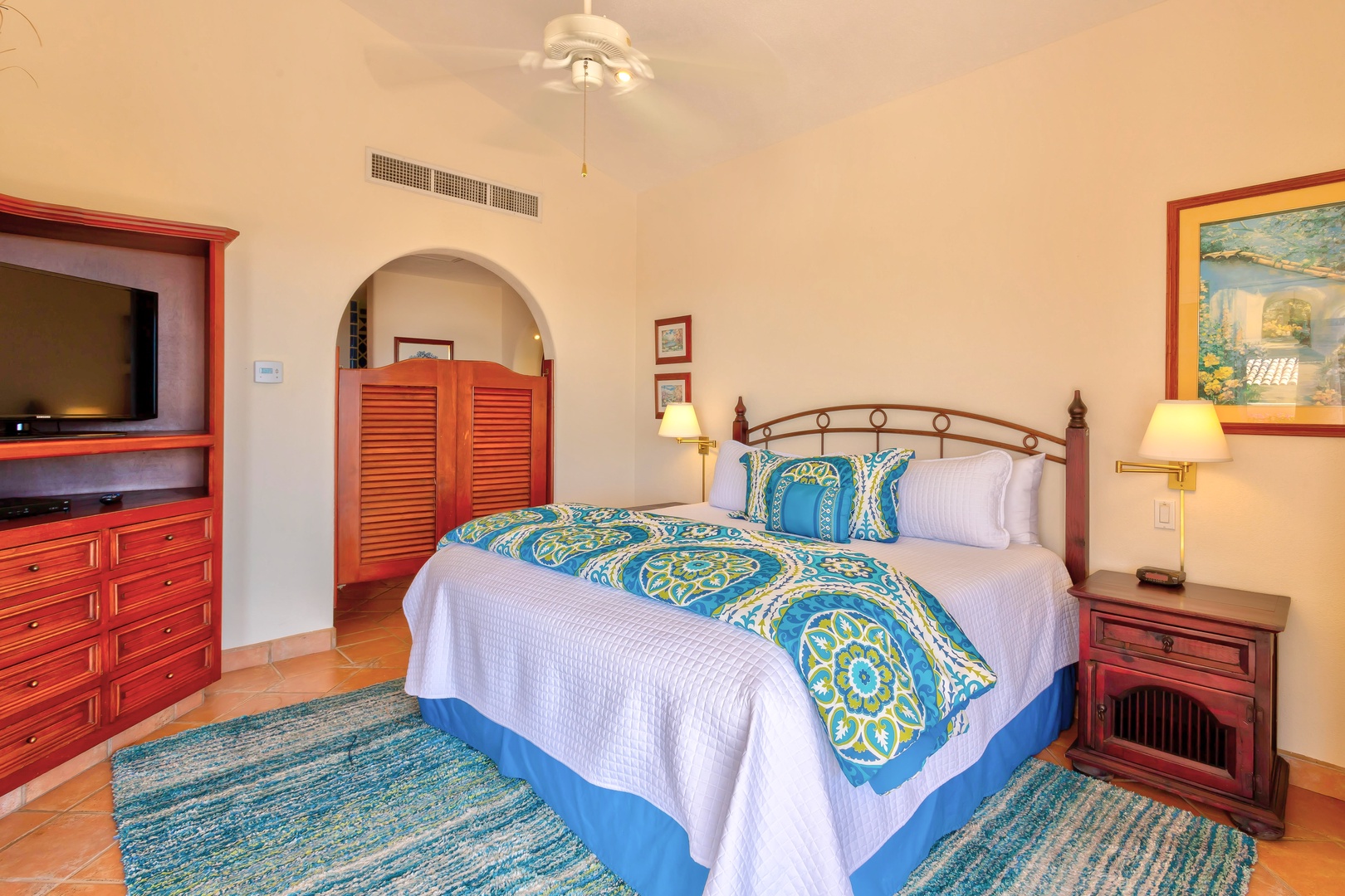 Sink into your luxurious king bed with vibrant blue bedding, surrounded by warm wooden furnishings and soft lighting for ultimate comfort.