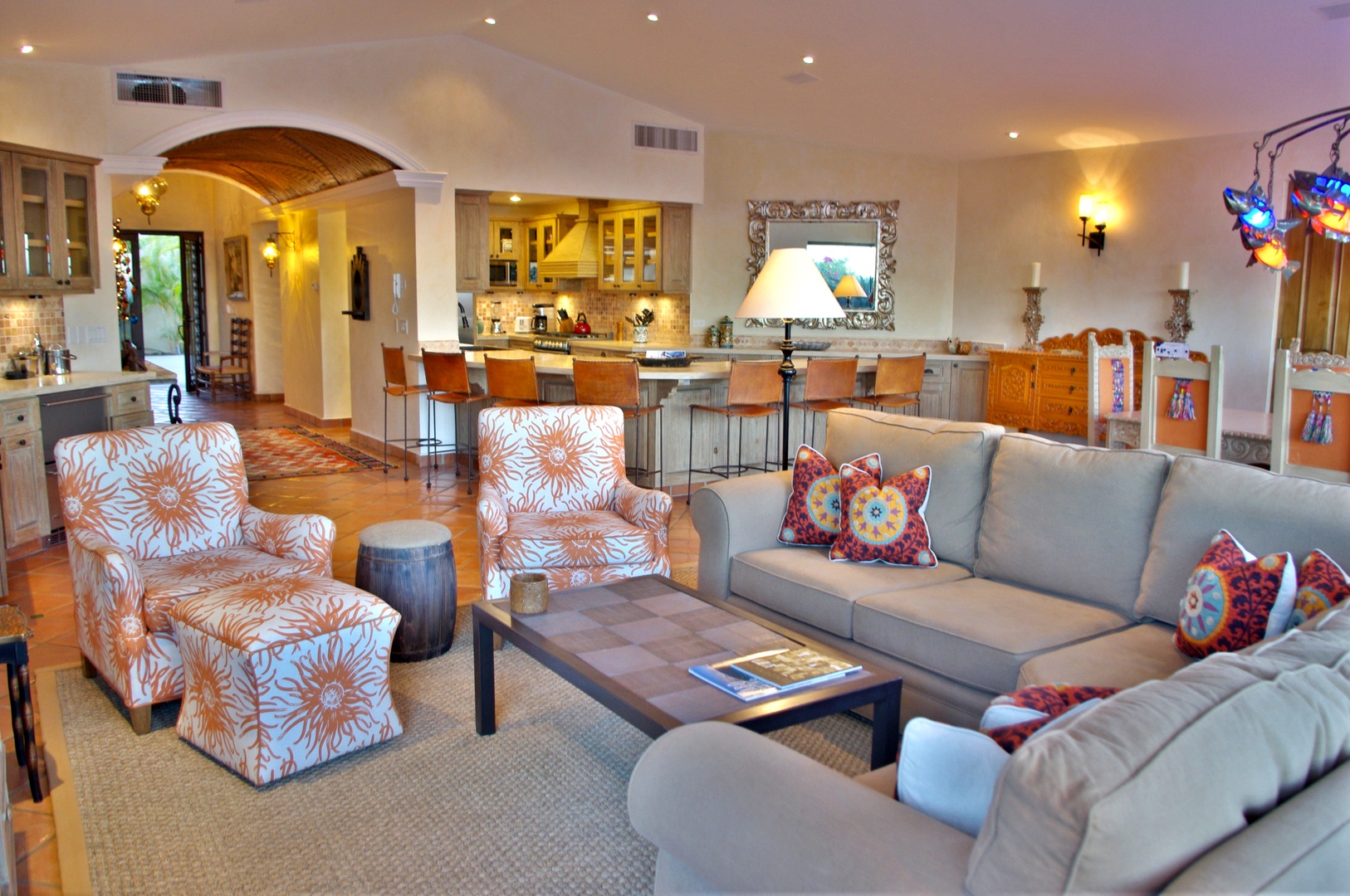 Settle into this spacious open living area where vaulted ceilings and warm lighting create an inviting atmosphere. Your vacation unfolds seamlessly from the cozy seating to the fully equipped kitchen and dining space.