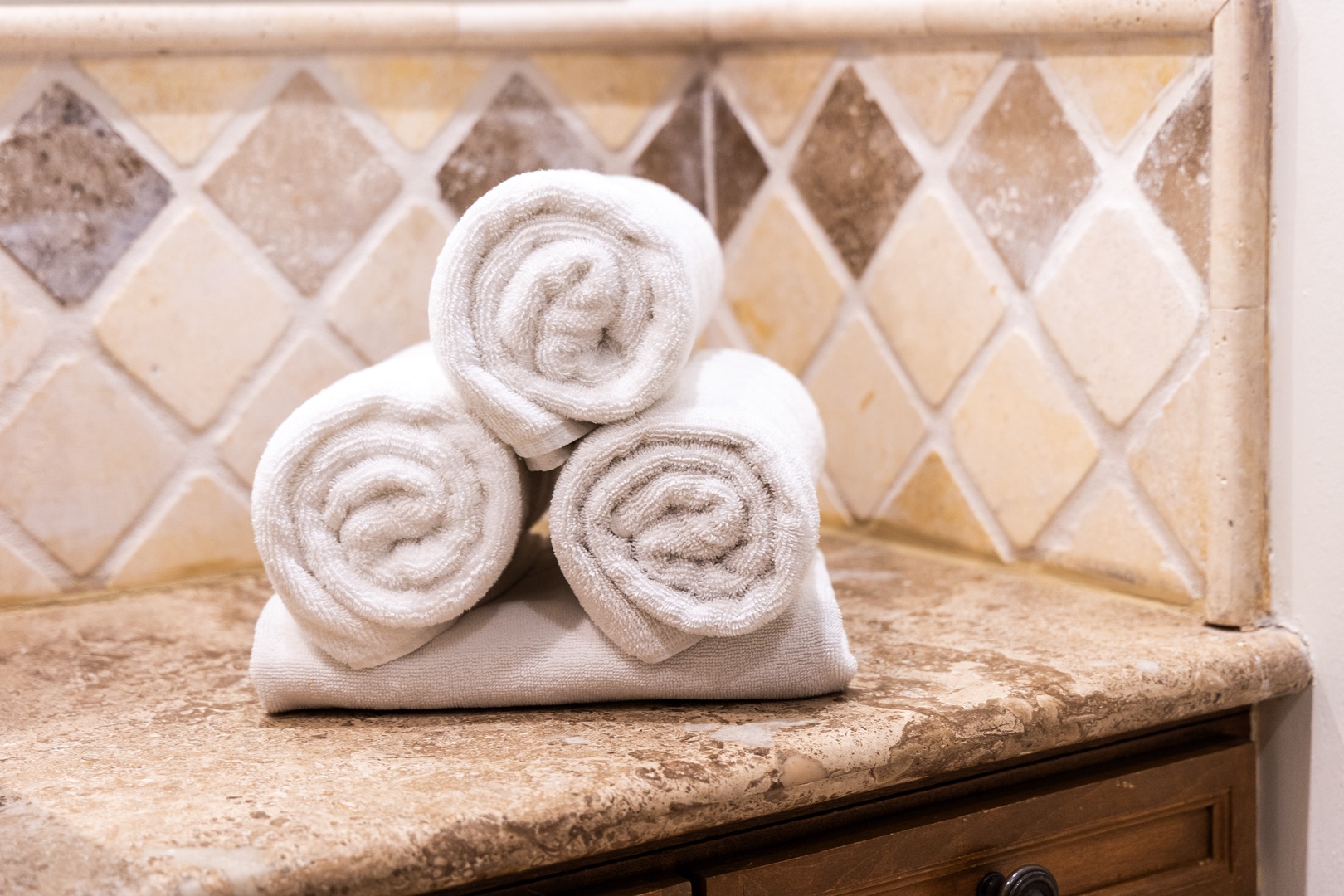 Fresh towels await you in the bathroom, set against warm earth-toned tile that brings a spa-like feel to your daily routine.