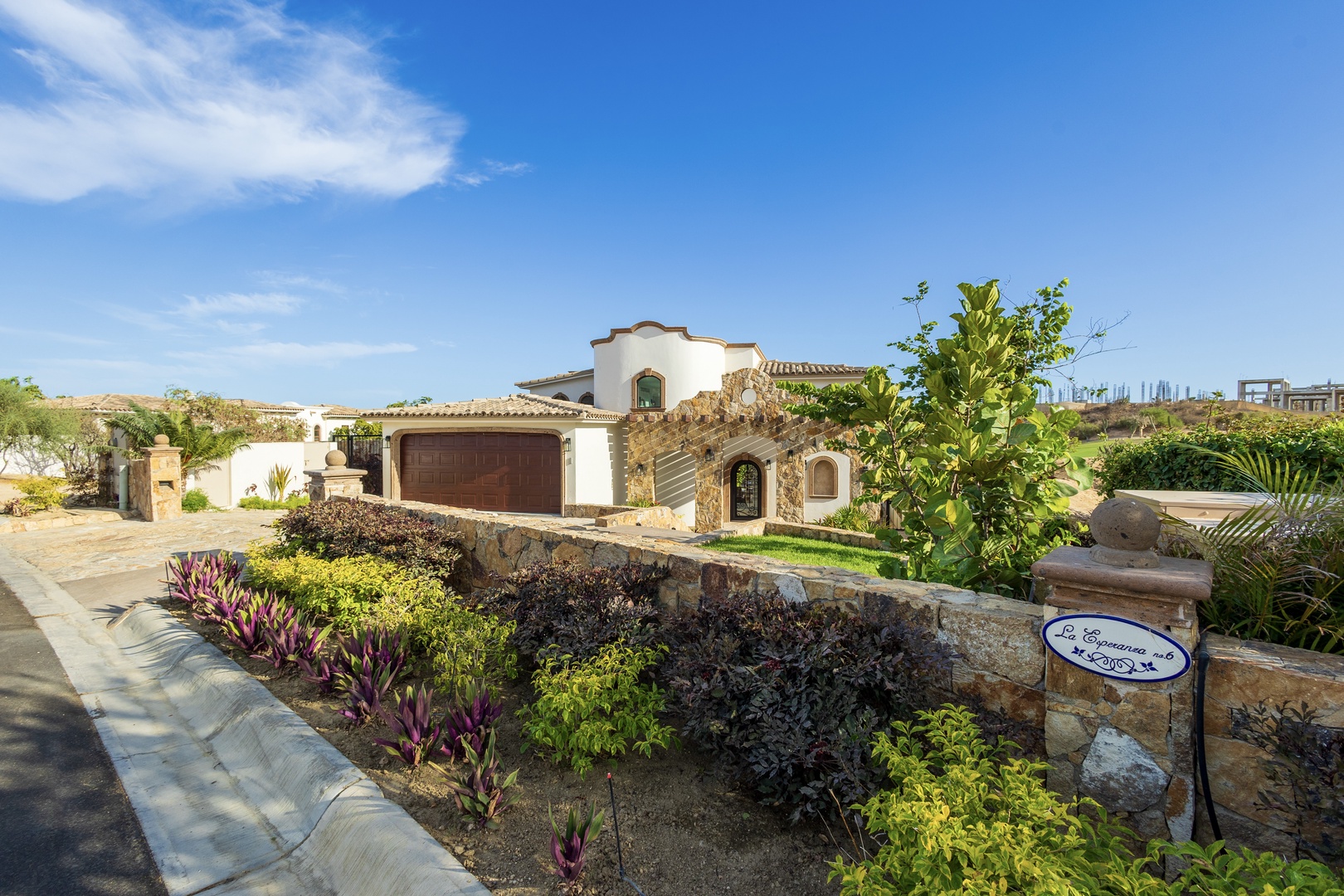 This Spanish-style villa features well-maintained gardens, stone-accented landscaping, and a warm desert ambiance, offering a serene and welcoming arrival to the property.