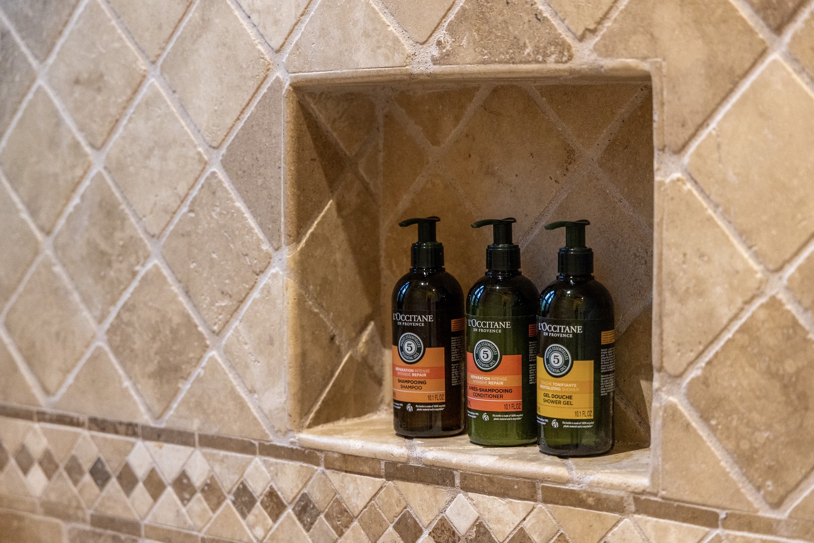 Premium L'Occitane toiletries await you in a beautifully tiled shower niche, ready to elevate your daily refresh into a spa-like experience.