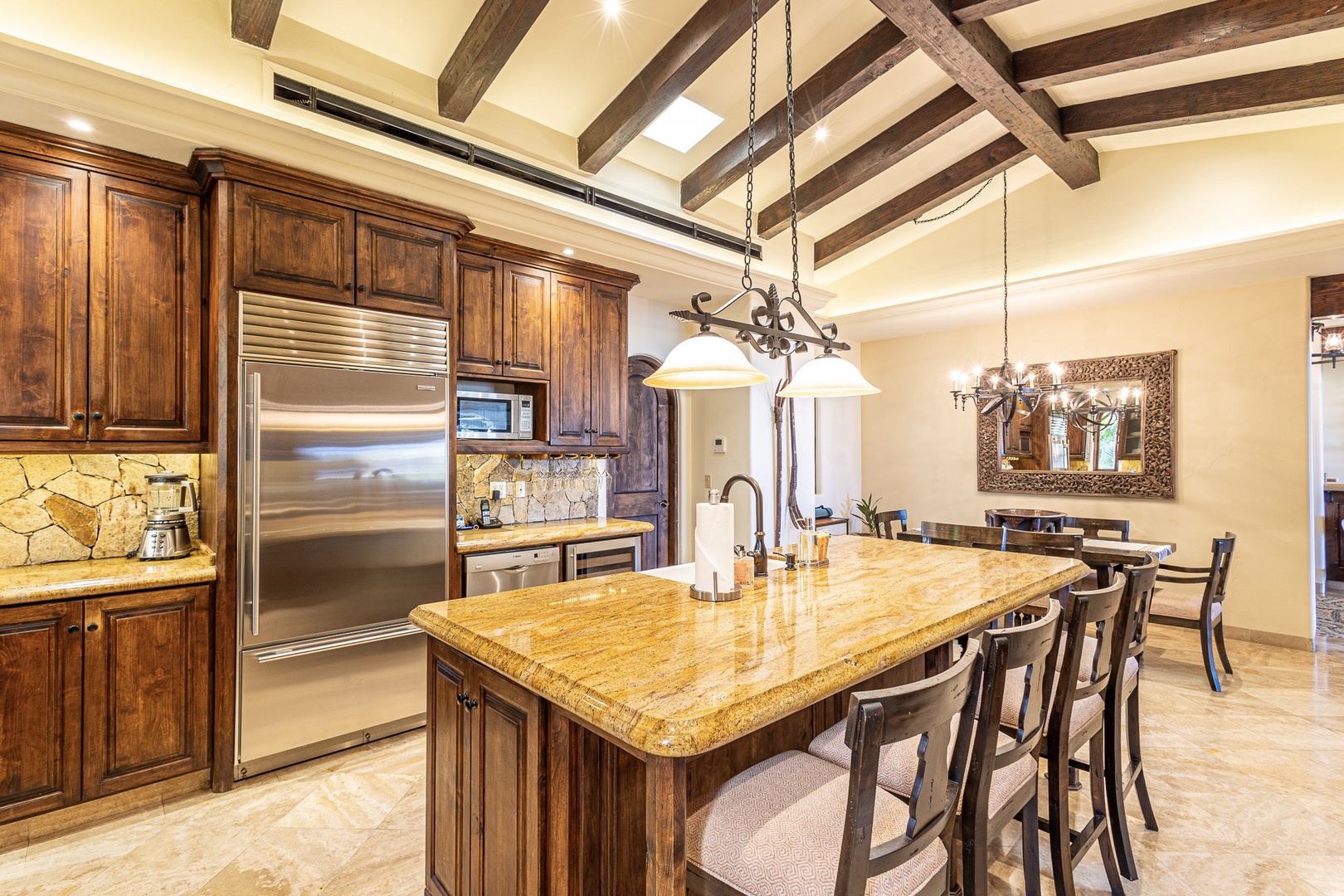 Gather around this spacious kitchen island where rustic wood beams and granite countertops create a warm, inviting space for your group to cook and connect together.