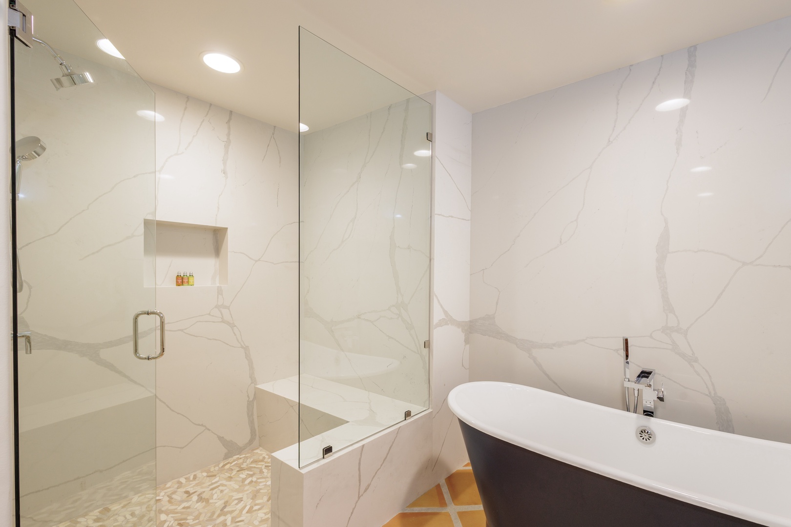 Step into your private marble spa with a sculptural freestanding tub and gleaming walk-in shower. The sleek glass partition and soft lighting create a serene escape after exploring.