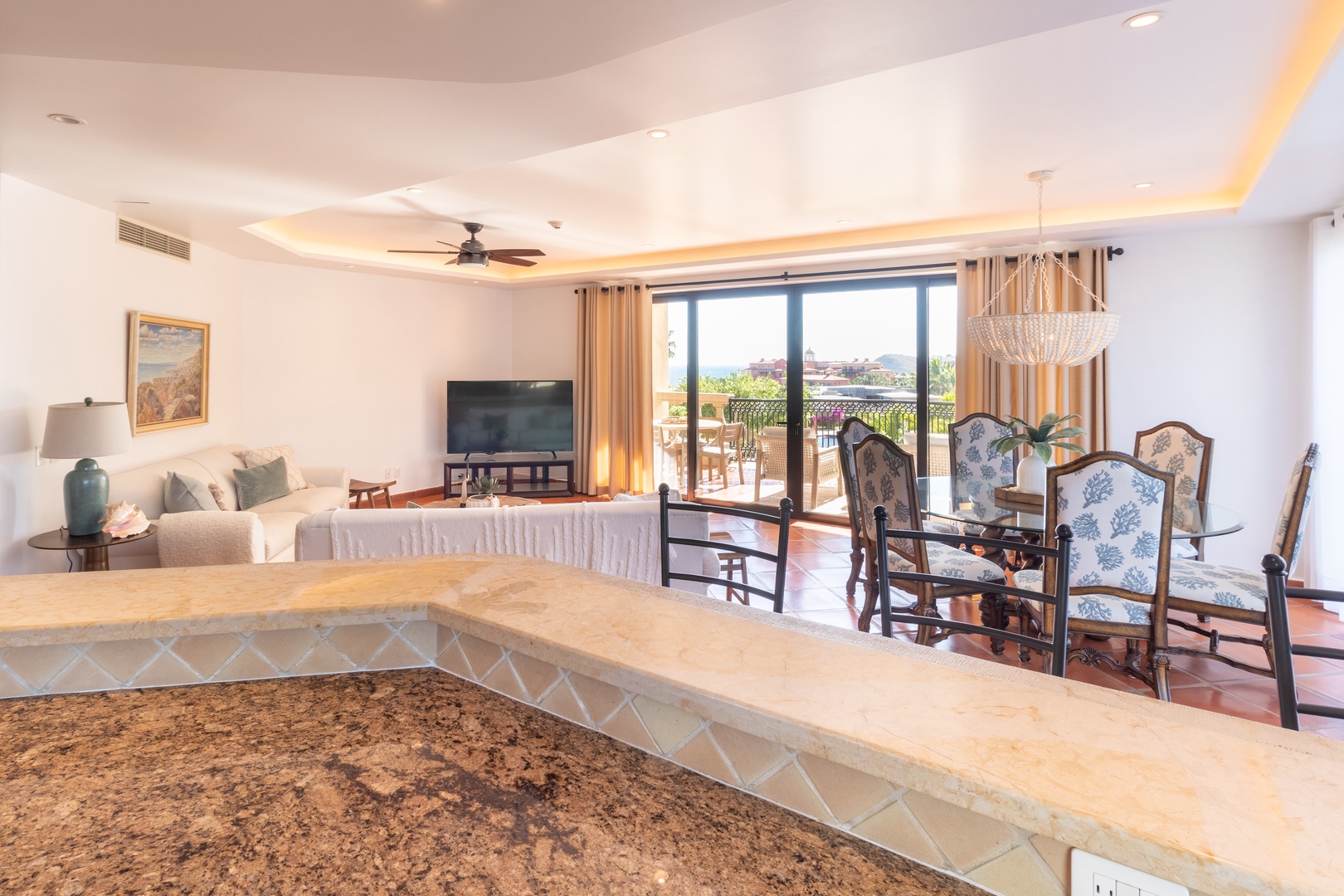 Picture yourself relaxing in this bright, open-concept living space with elegant furnishings, modern entertainment, and stunning balcony views beyond. The design invites you to unwind, dine, and create lasting memories in comfort and style