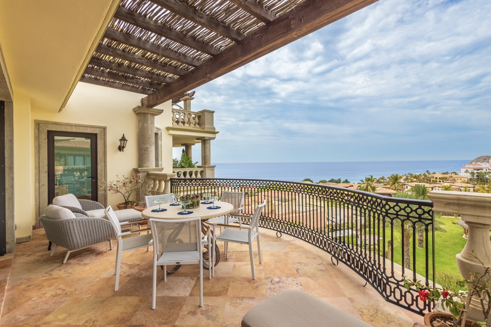 Sip your morning coffee on this elegant curved balcony overlooking lush gardens and the sparkling sea beyond.
