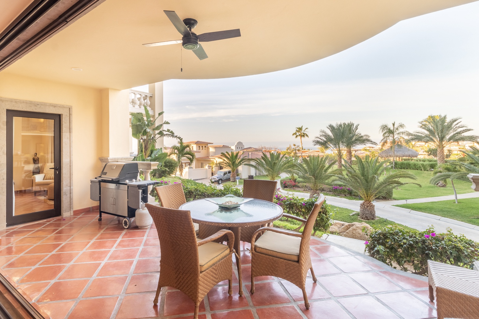 Picture yourself grilling fresh catch as palm trees sway and lush gardens stretch before you—your perfect spot for morning coffee or sunset cocktails awaits.