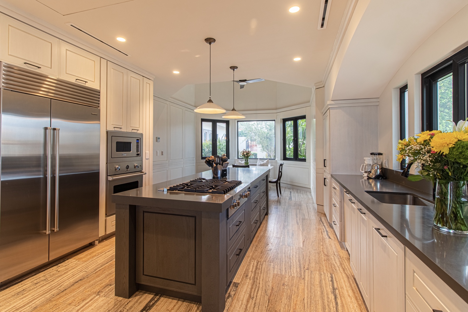 Imagine prepping your favorite meals in this gourmet kitchen with top-tier appliances, sleek countertops, and an expansive island. Bright windows frame your culinary experience with natural light.