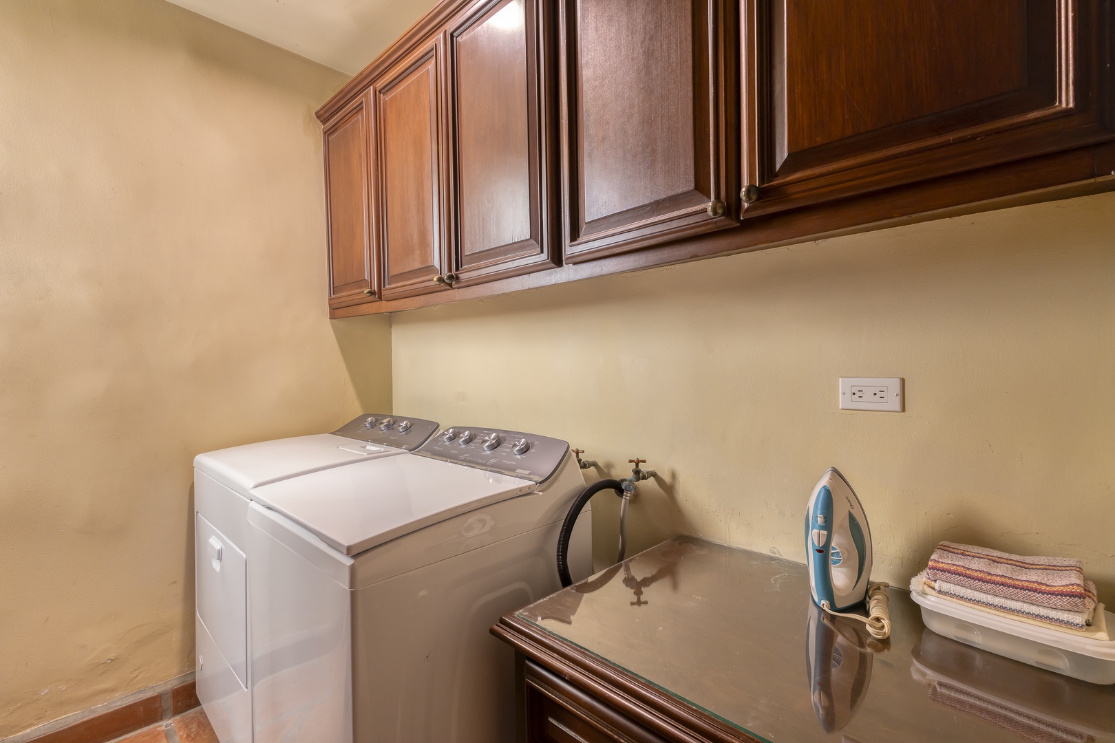 Your dedicated laundry room features full-size washer and dryer with elegant wood cabinetry for convenient storage.