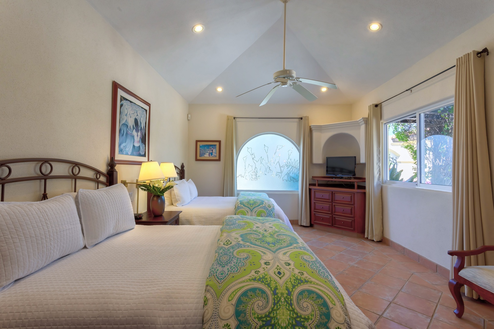 Step into your peaceful retreat featuring comfortable twin beds, vaulted ceilings, and a unique arched window that frames scenic views.
